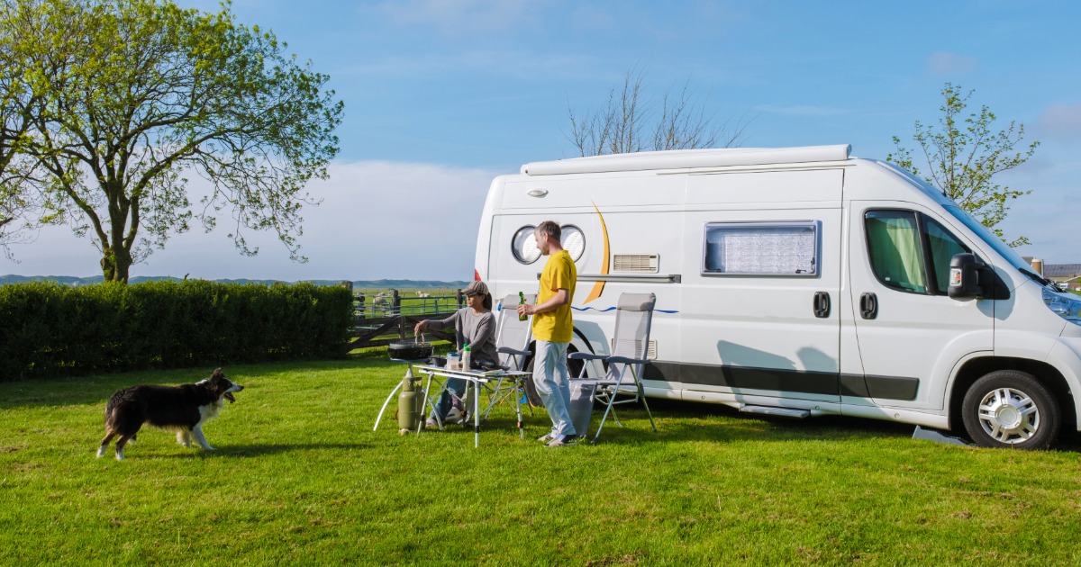 A couple enjoying the outside of their camper van at a rally.